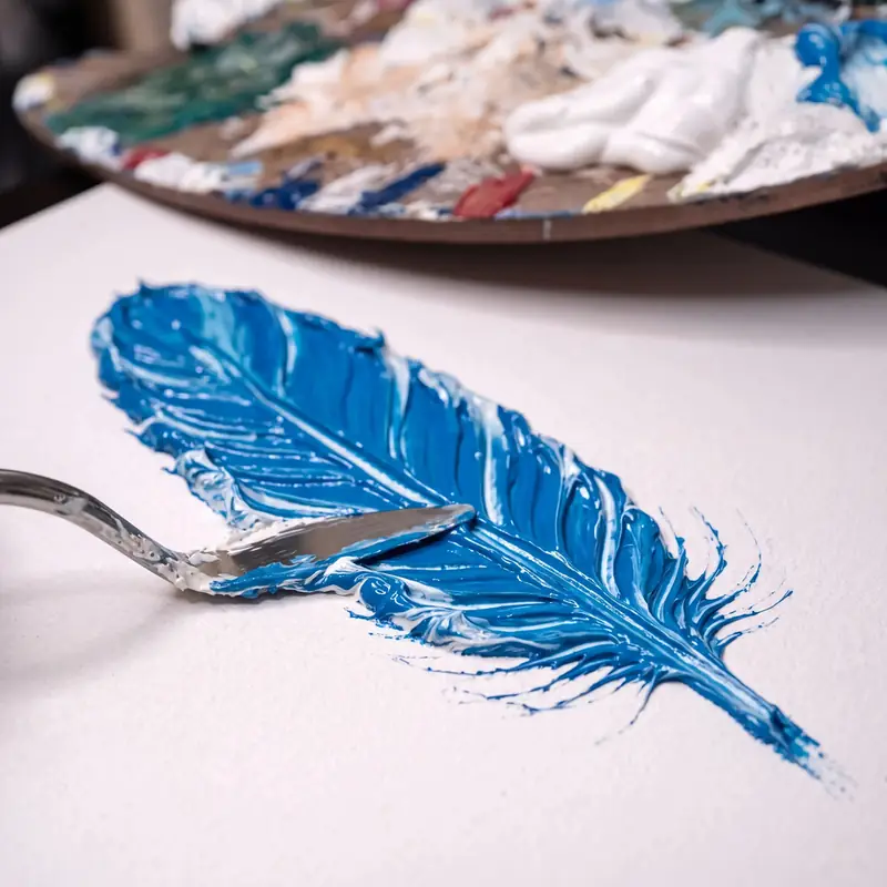 Palette knife loaded with textured paint paste